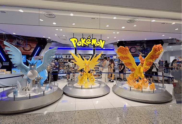 Estátuas de Articuno, Zapdos e Moltres na entrada de um Pokémon Center no Japão