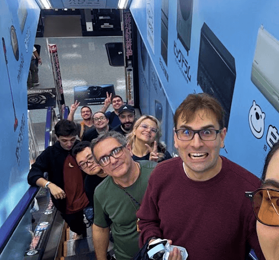 Grupo de viajantes tirando selfie na escada rolante de uma loja de games em Tóquio